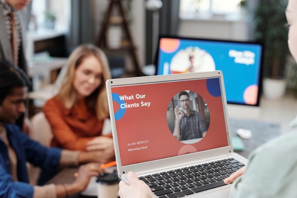 Group of people gathered together with a laptop facing away from others featuring what clients say about Ed Neir Construction.