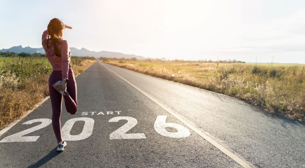 Ed Neir Construction wishes all a Happy New Year - a woman in workout clothes is stretching & looking in the distance, ready to start 2026