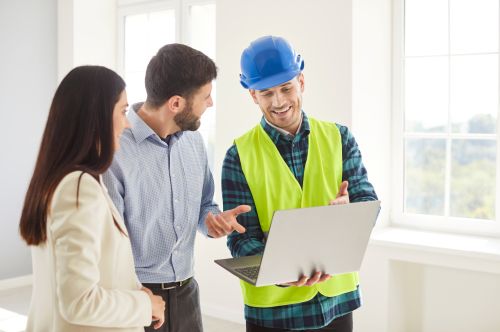 Ed Neir Construction urges homeowners to bring in a licensed contractor to save nerves, money + time. Happy Couple agrees as they work with contractor who has laptop with plan.