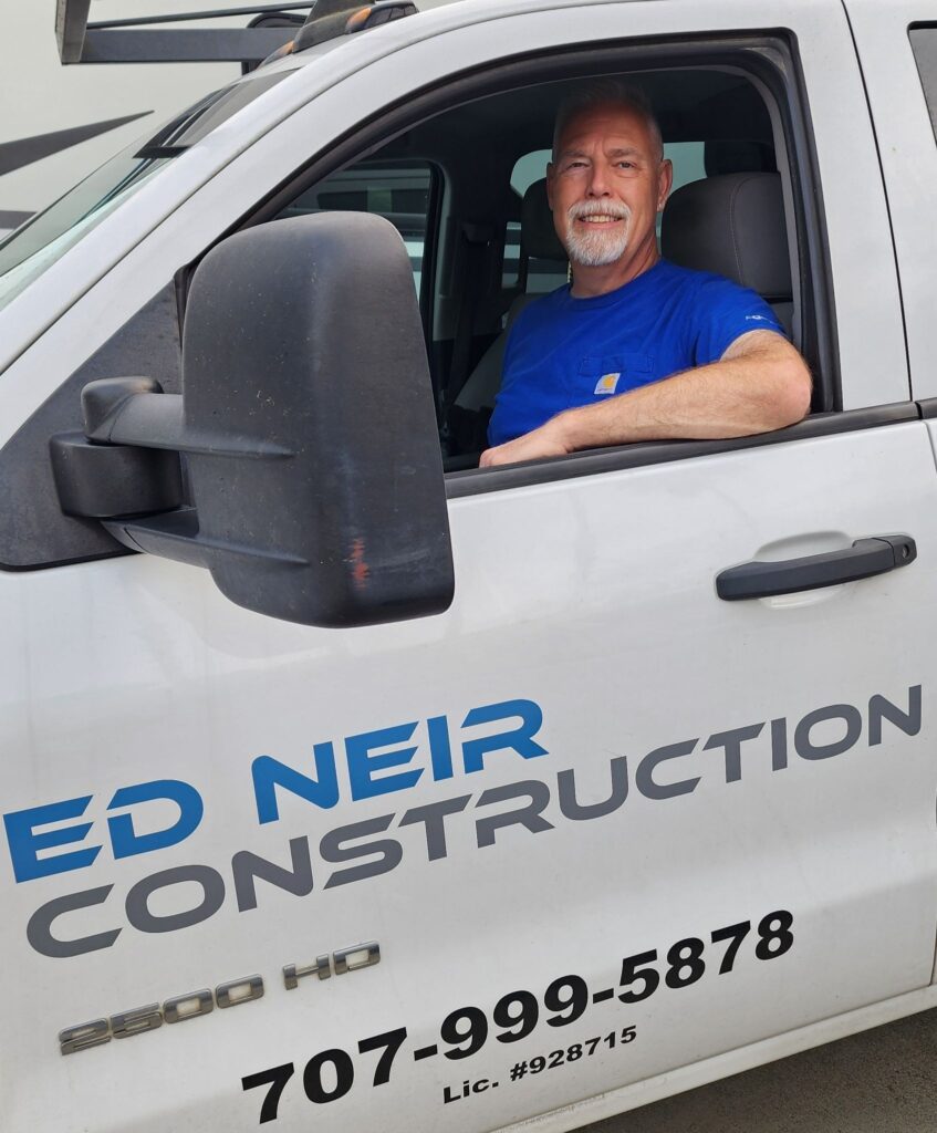 Ed Neir, BBB A+ rated licensed general contractor, expert provider of home, commercial + Ag construction solutions, in a truck.