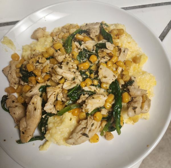 Neir Kitchen Recipe: Creamy Chicken with Corn and Spinach on Cheesy Polenta served on white plate.