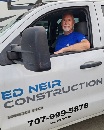 Ed Neir, BBB A+ rated licensed general contractor, expert provider of home, commercial + Ag construction solutions, in a truck.